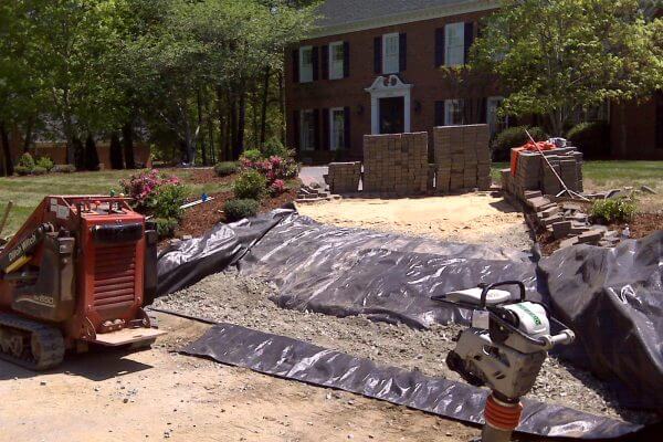contractor placed paver driveway over utilities, trenches were not compacted, 1/3 of driveway needed to be repaired by Outdoor Contracting