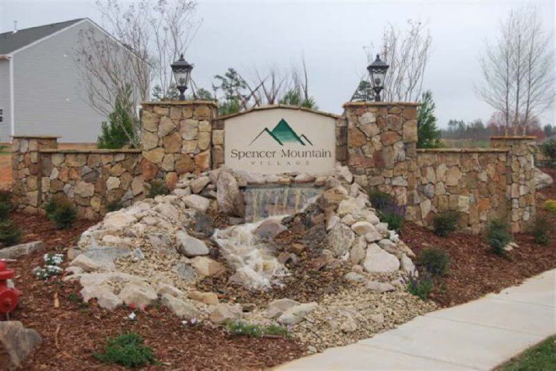 Neighborhood Entrance Monument Sign Construction | Custom Stone Community Identity Feature | Luxury Entrance Monument Design | Engineered Hardscape Signage for Residential Developments